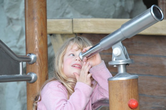 Mädchen mit Fernrohr auf dem Spielplatz Mädchen mit Fernrohr auf dem Spielplatz